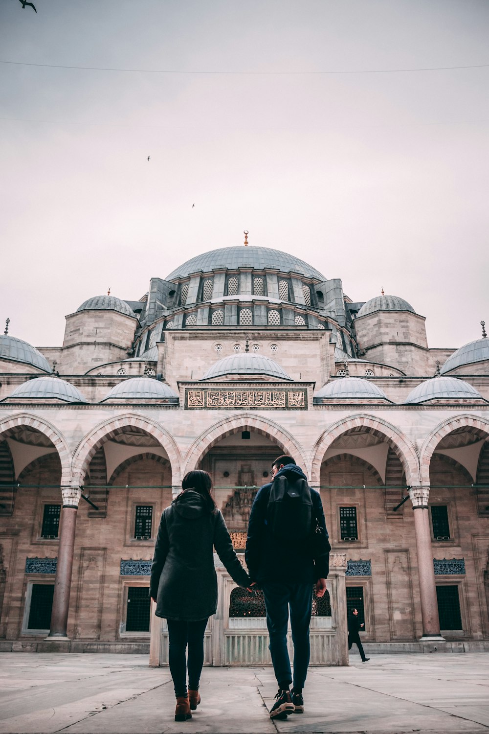 man and woman holding hands near building