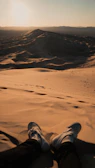 Close-up of feet pounding the earth during a desert marathon at dawn.