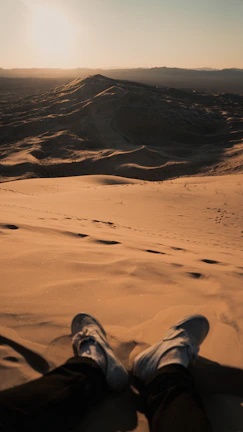 Close-up of feet pounding the earth during a desert marathon at dawn.