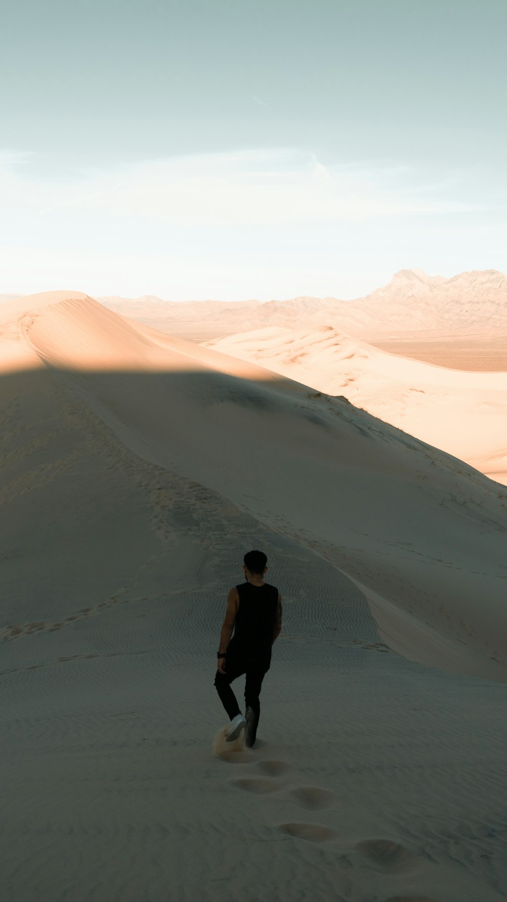 man walking along desert during daytime