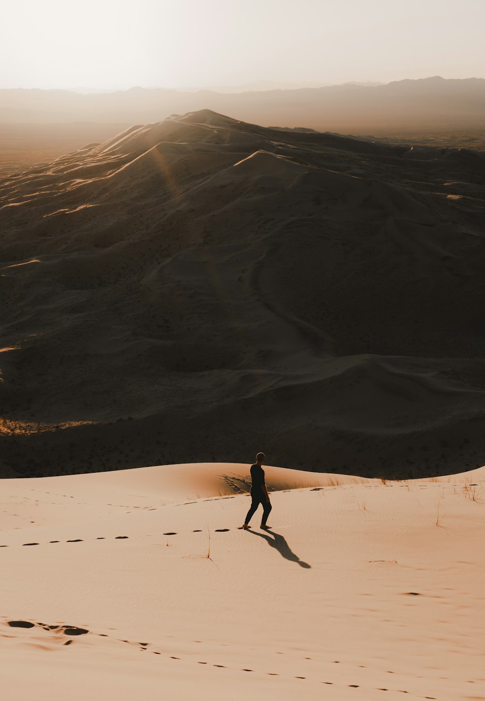 person standing near mountains during golden hour