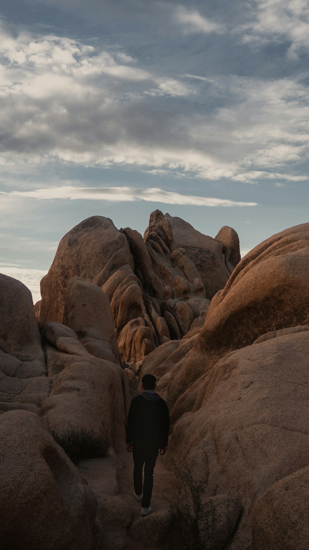 man walking towards a rocky mountain