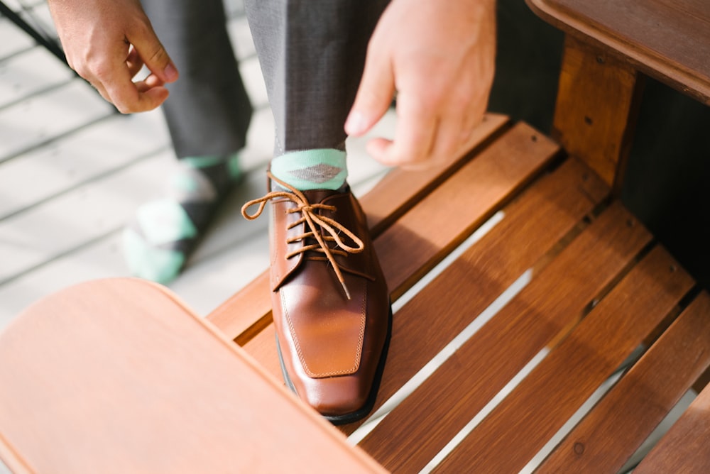 Persona en zapato de vestir marrón en sillón