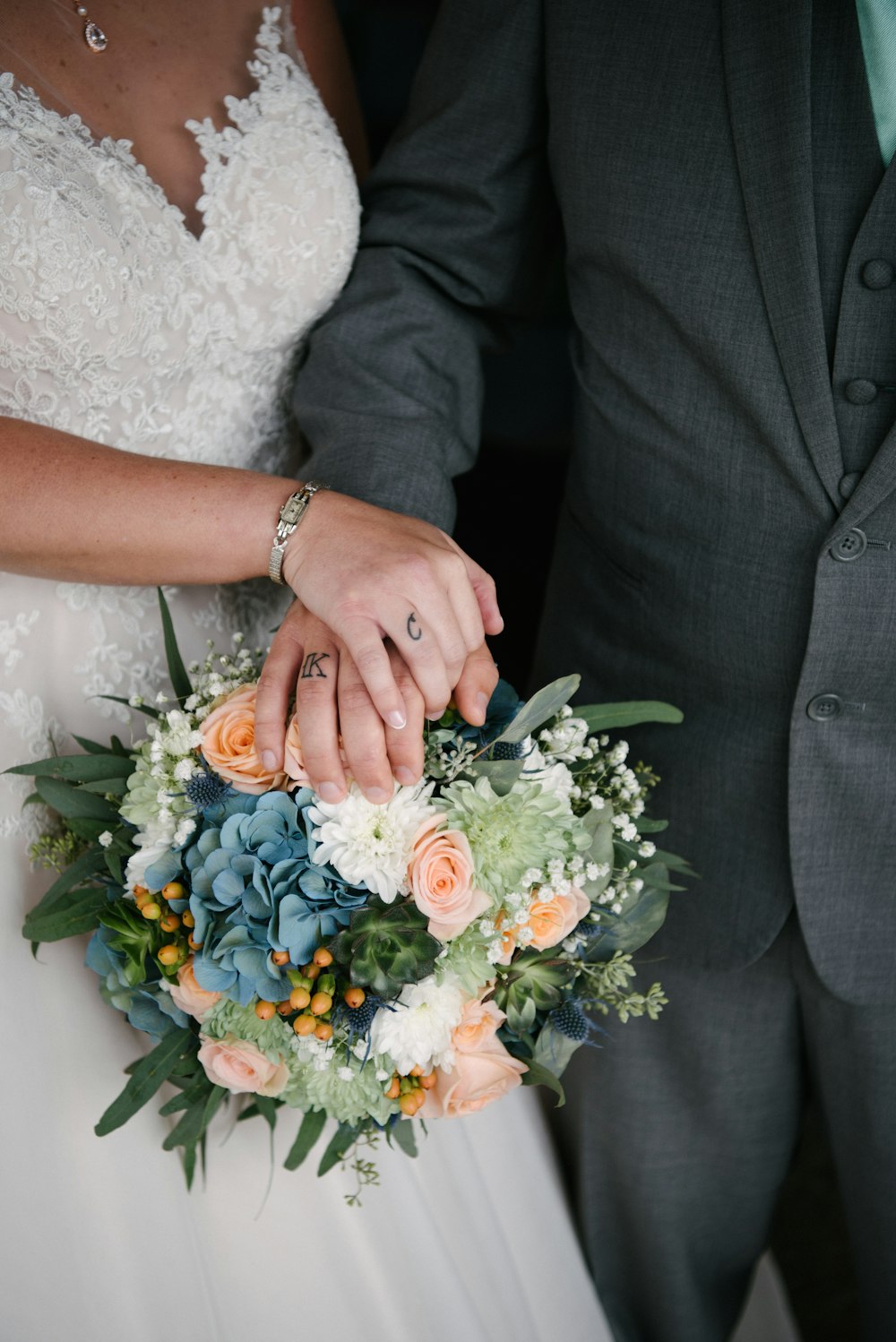 woman holding bouquet of flowers beside man touching it