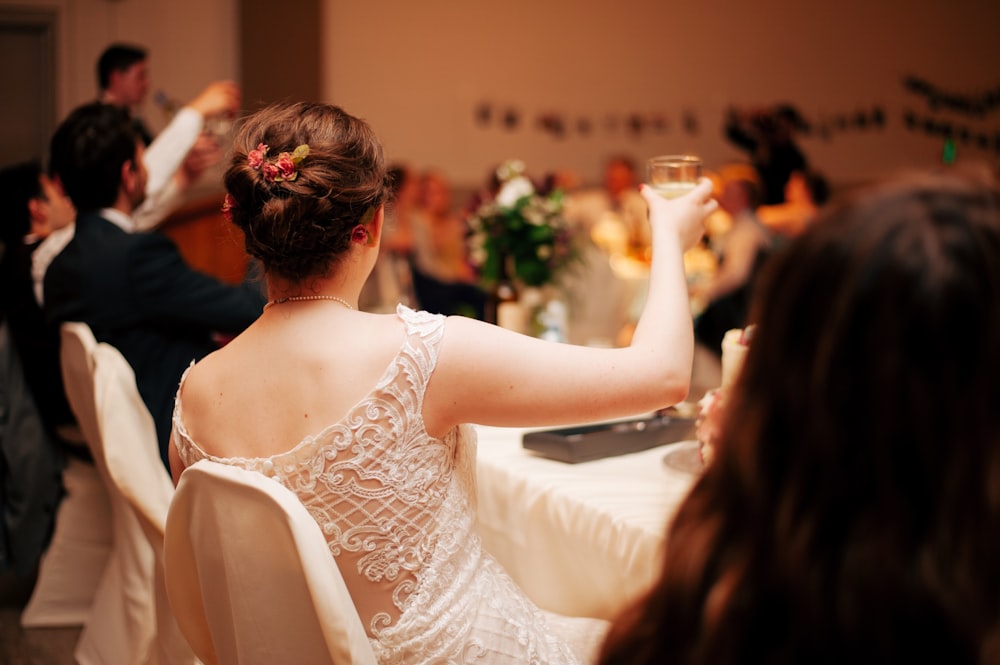 shallow focus photo of woman holding clear drinking glass