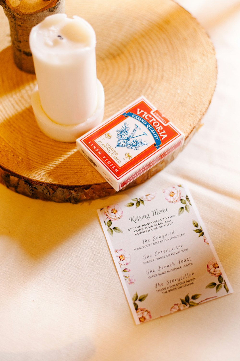 red and white Victoria gaming card box beside white pillar candle