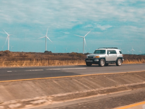 A sleek Silver Raine transport van cruising down a sunny highway.