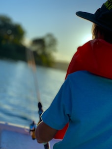 Angler wearing oceanic sportfishing apparel on a boat at sunrise.
