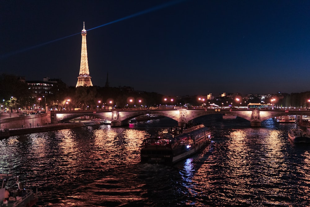 boat on river near Eiffel tower at nighttime
