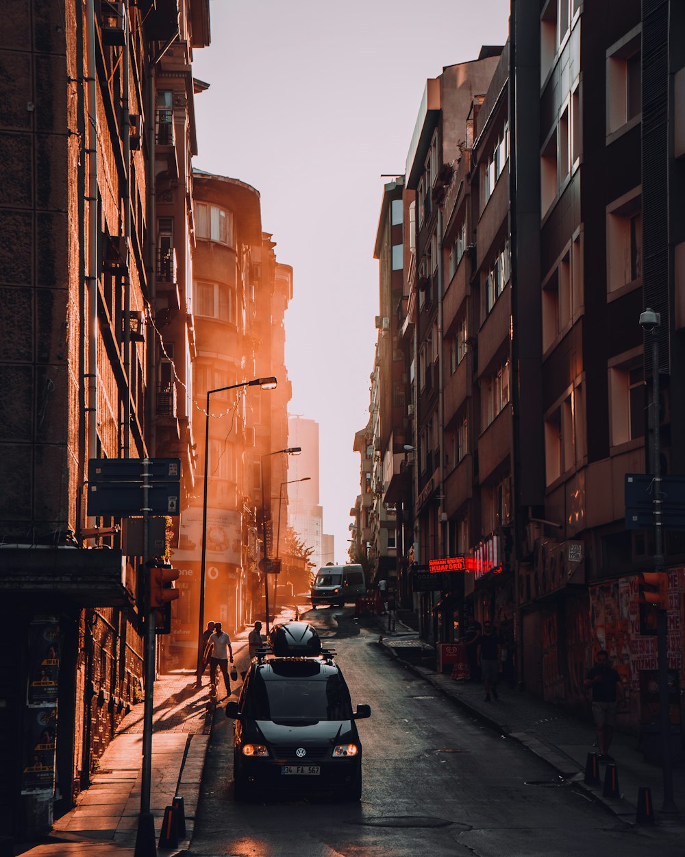 car parked on road by buildings under white skies