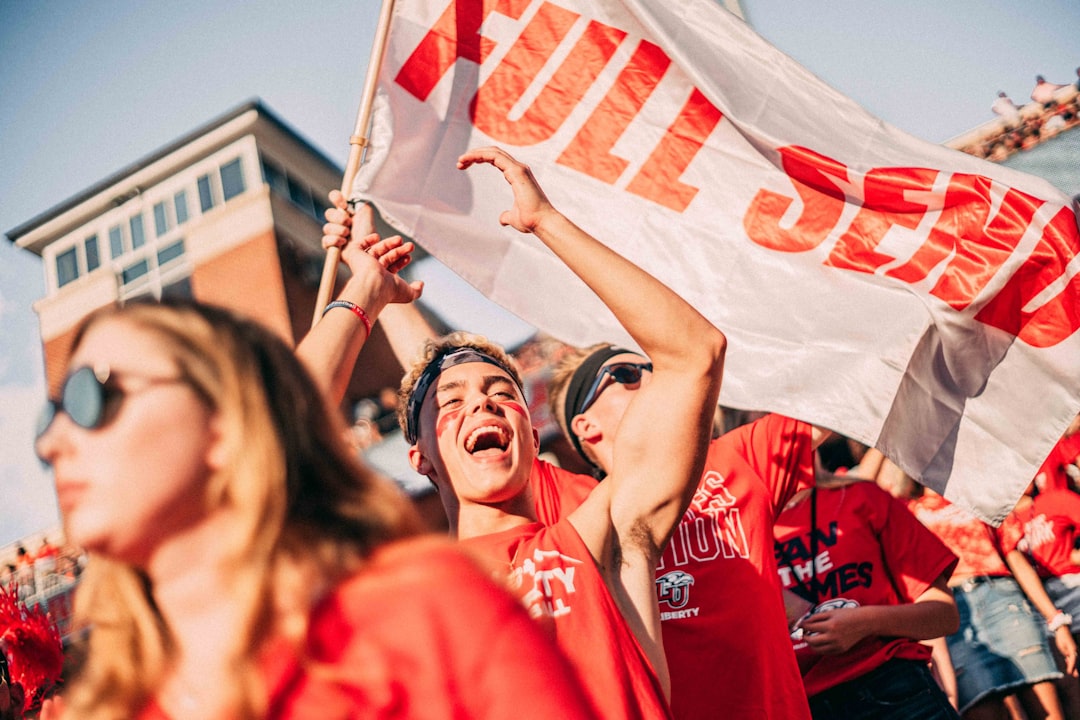 people wearing a red shirt holding banner during daytime