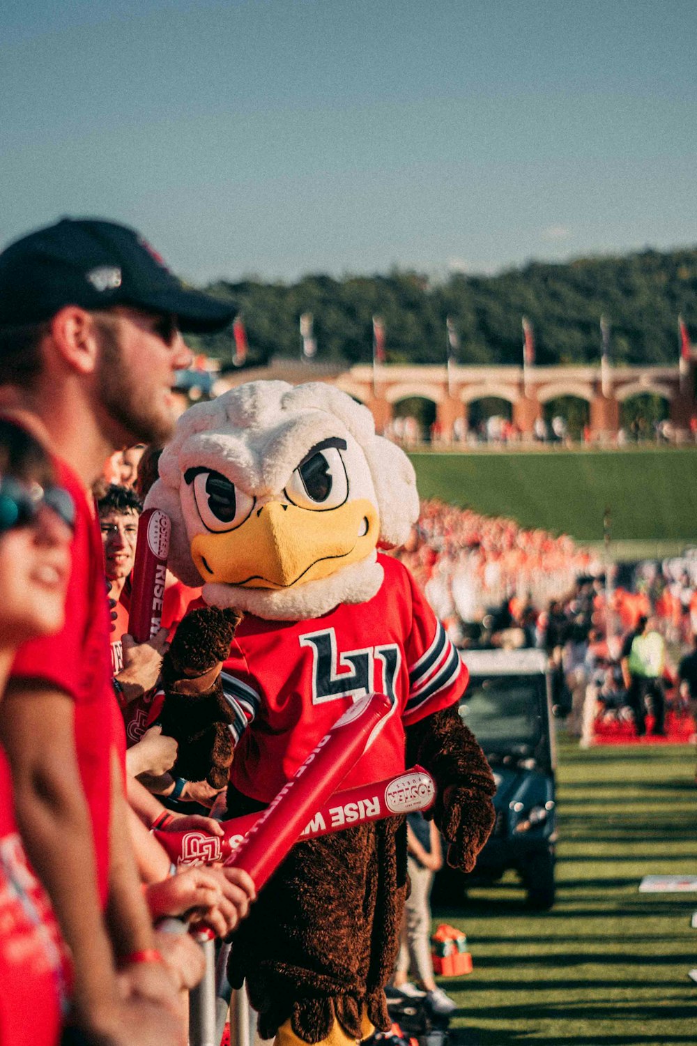 man standing beside mascot