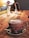 A warm café setting with steaming cups of coffee on a wooden table.