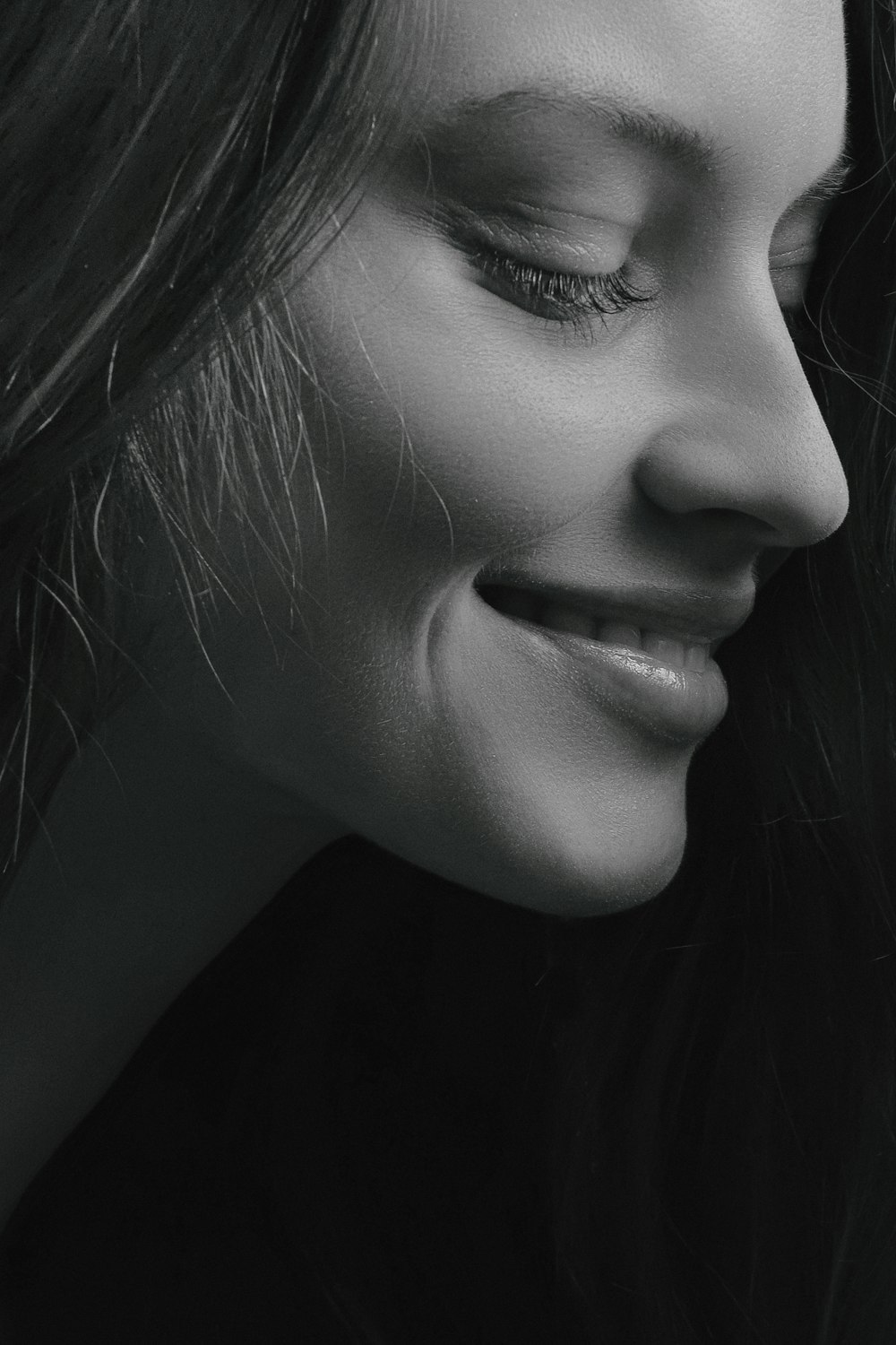 Foto en escala de grises de una mujer sonriente