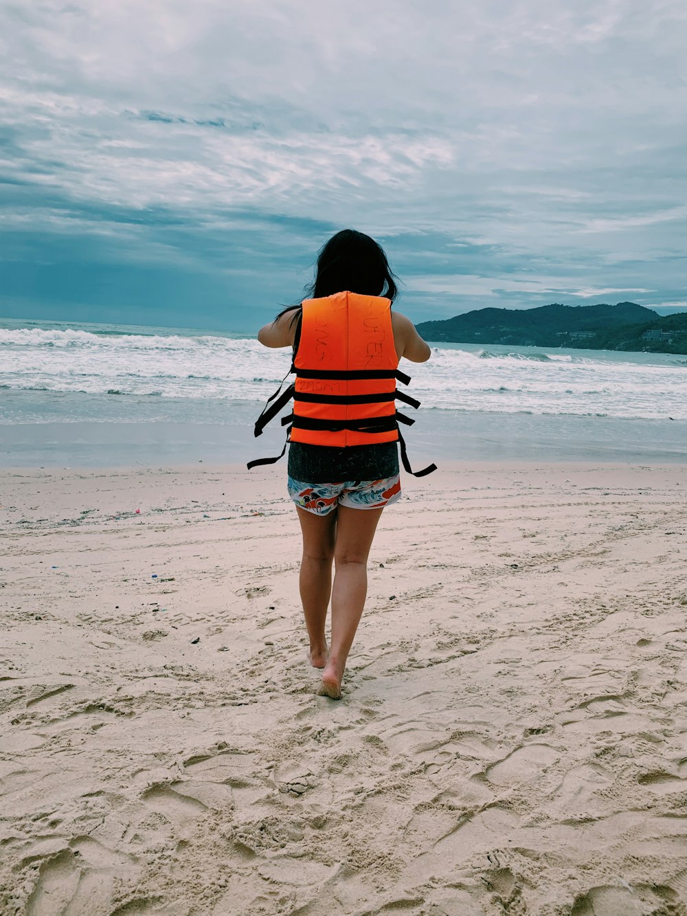 woman walking towards beach