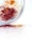 A silver plate contains piles of colorful spices, with red and orange hues scattered across a white surface.