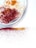 A silver plate contains piles of colorful spices, with red and orange hues scattered across a white surface.