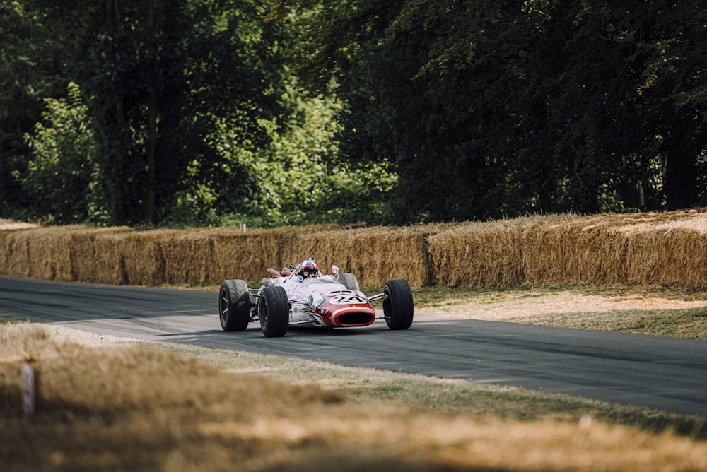 person riding racing car on road