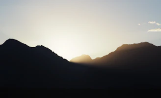 Recovery phase icon featuring a rising sun behind a mountain in soft gold and navy hues.