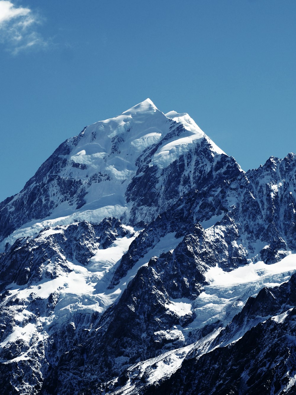 montagne enneigée sous un ciel bleu calme pendant la journée