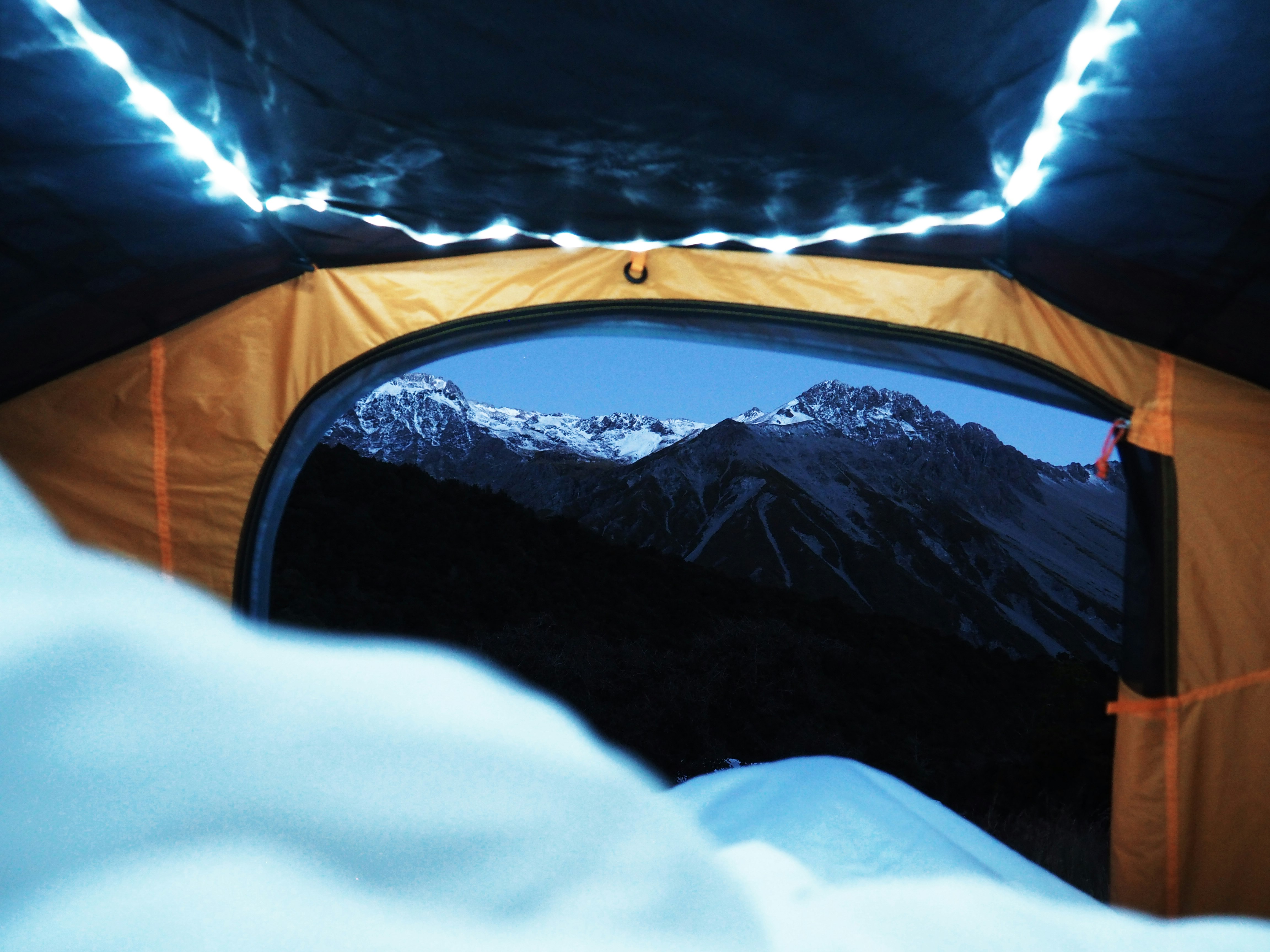 orange and black tent near mountains