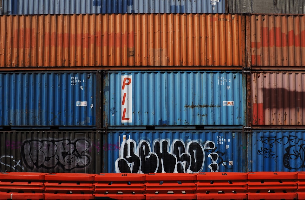 a red bench sitting in front of a bunch of containers