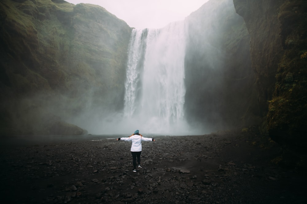 person stands near waterfalls
