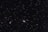 A vast, star-filled sky with countless stars scattered across the dark expanse. Two prominent galaxies are visible: a spiral galaxy with a bright core and extended arms on the right, and a smaller, elongated galaxy on the left.