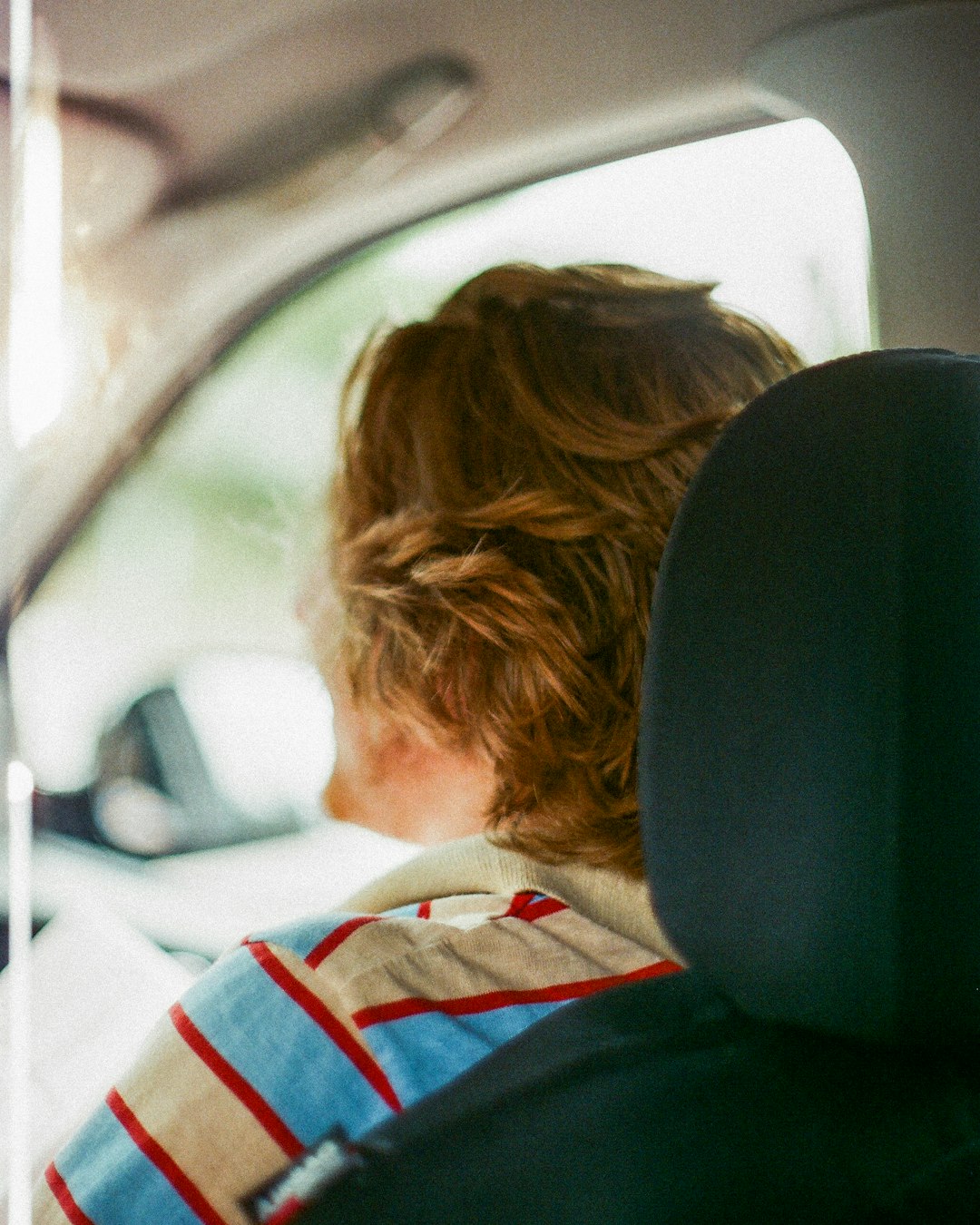 person with blonde hair beside driver's seat