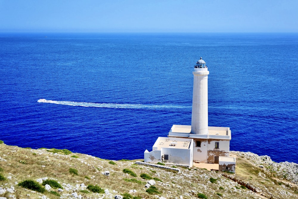 white lighthouse beside body of water