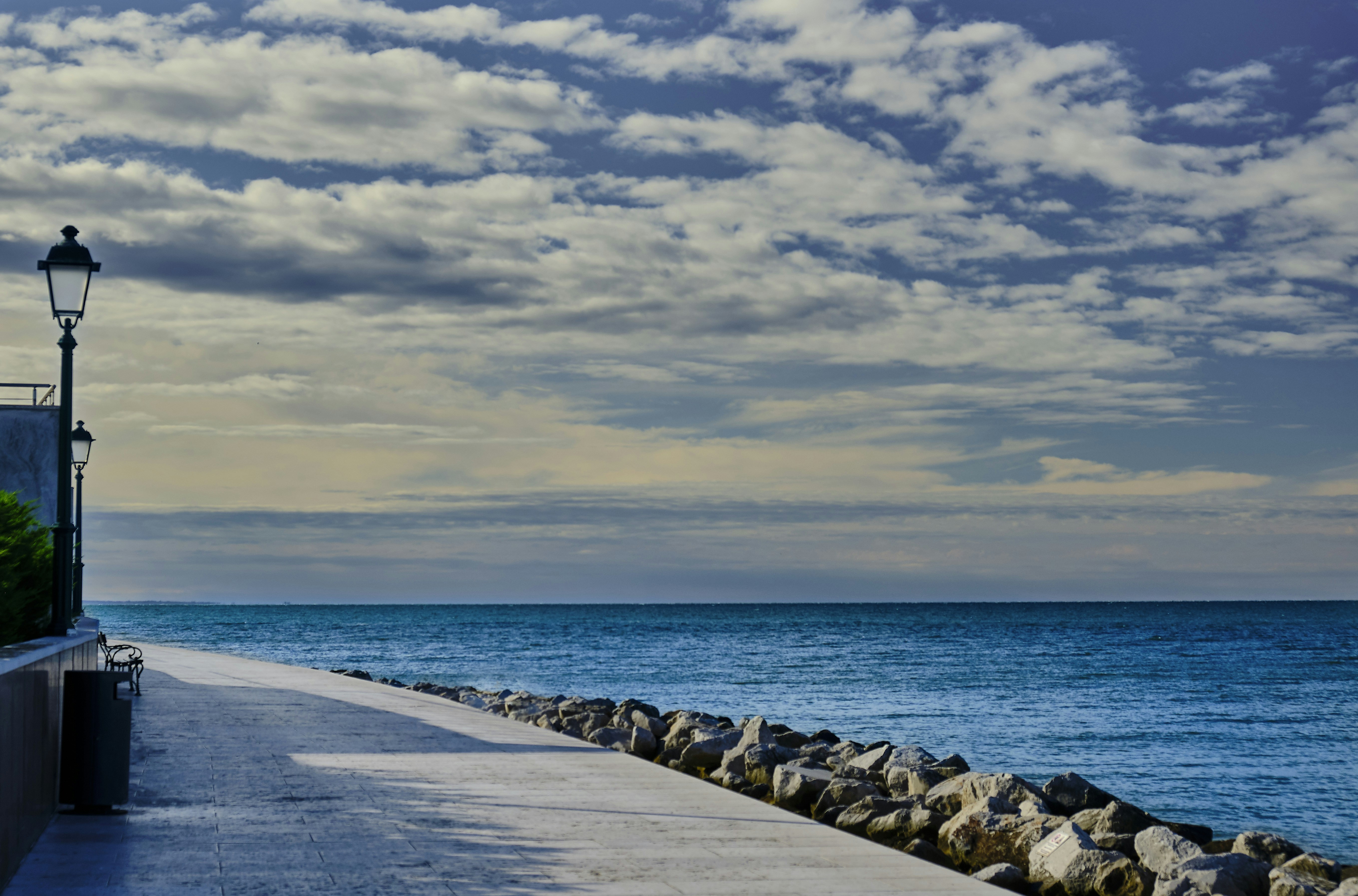 rocks near road and ocean