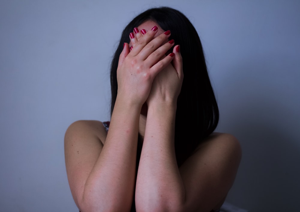 a woman covering her face with her hands