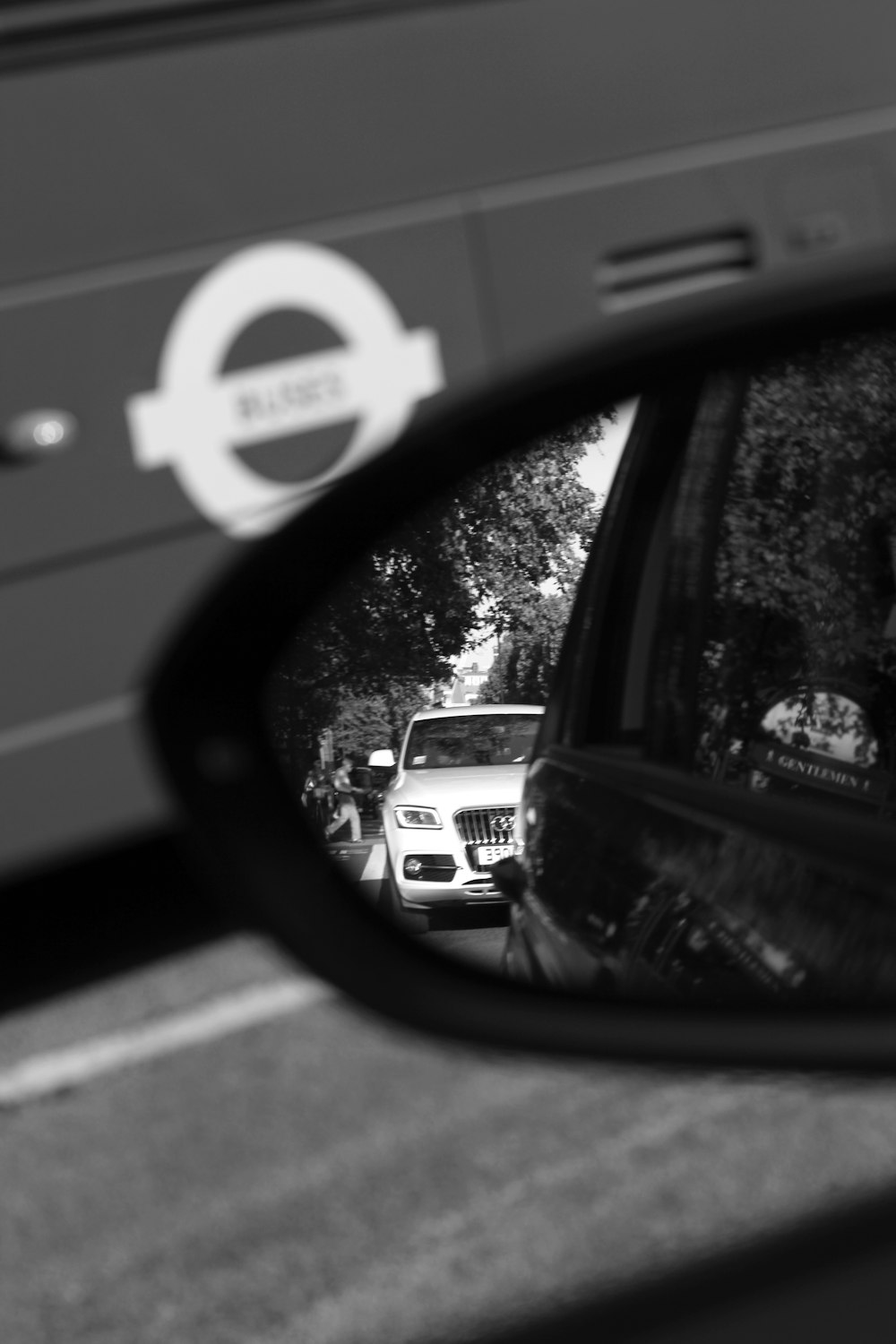 a rear view mirror on a car with a bus in the background