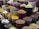 A vibrant display of various spices and herbs arranged in multiple large bowls. The containers are filled with colorful ingredients, such as dried peppers, turmeric, and other spices, creating a visually appealing and aromatic market scene.