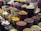 A vibrant display of various spices and herbs arranged in multiple large bowls. The containers are filled with colorful ingredients, such as dried peppers, turmeric, and other spices, creating a visually appealing and aromatic market scene.