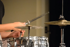 Close-up of hands playing a traditional drum with focus and joy.