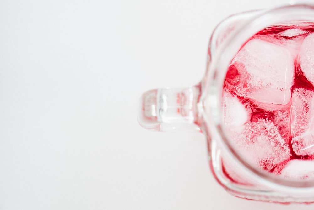 a glass filled with ice sitting on top of a table