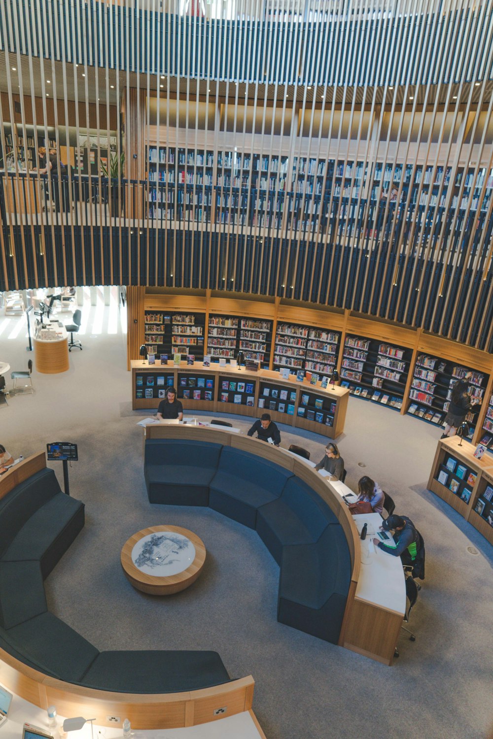 a library with a circular seating area and lots of books