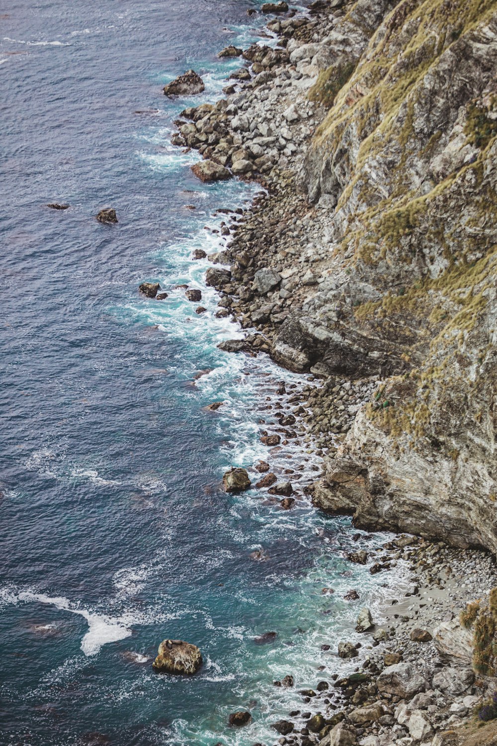 waves crashing on shore with rocks at daytime