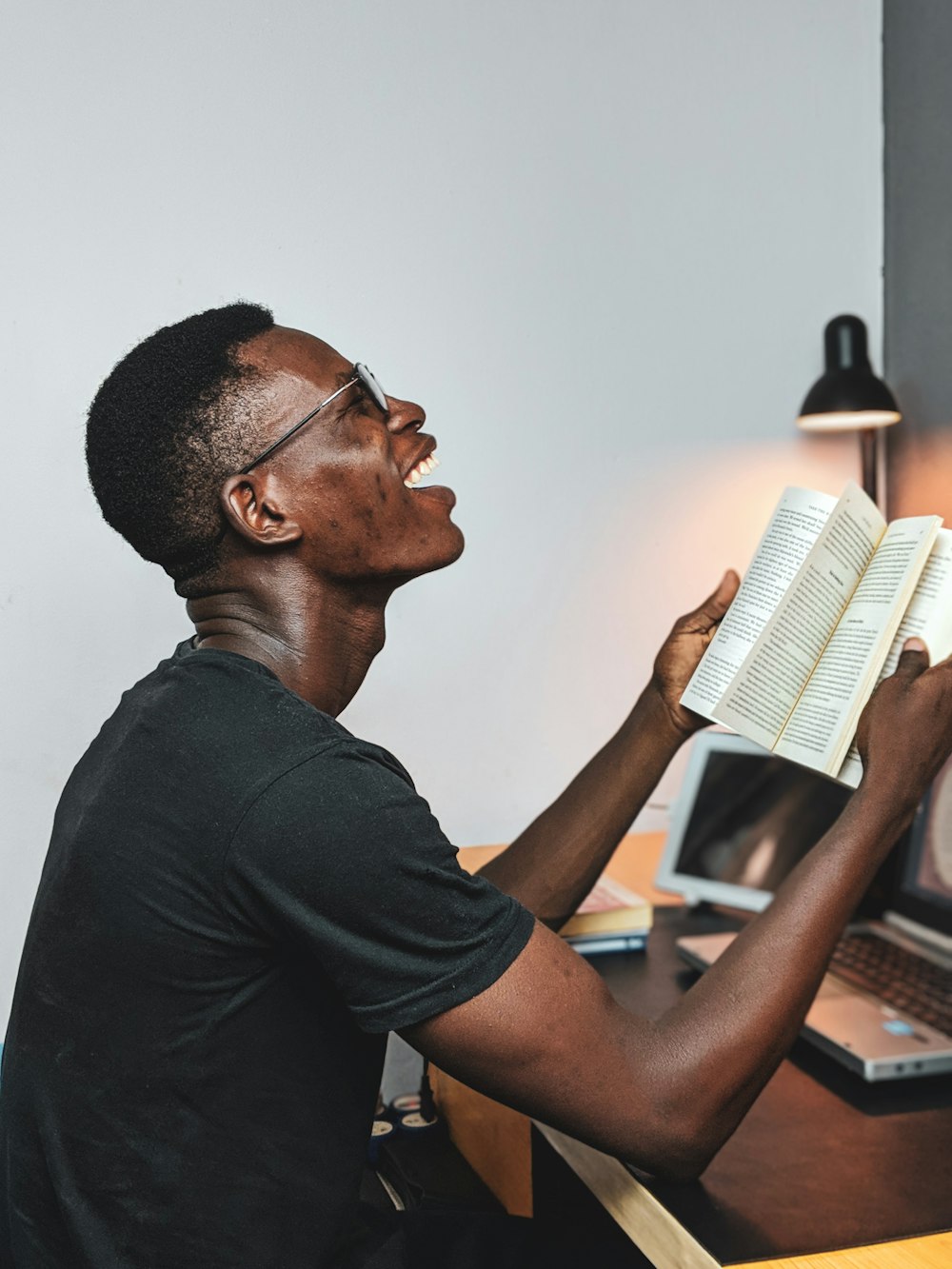 man reads book and smiles