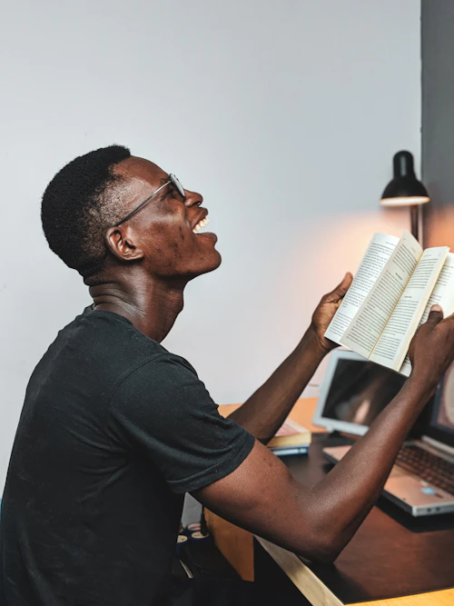 Student reading and smiling while studying
