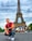 smiling man sitting by group of people near Eiffel tower