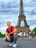 smiling man sitting by group of people near Eiffel tower