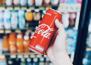 person holds Coca-Cola can