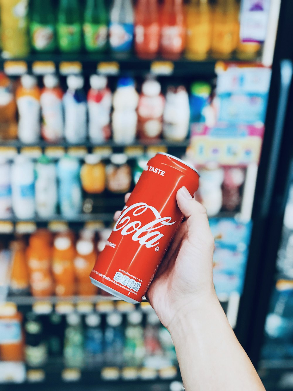 person holds Coca-Cola can