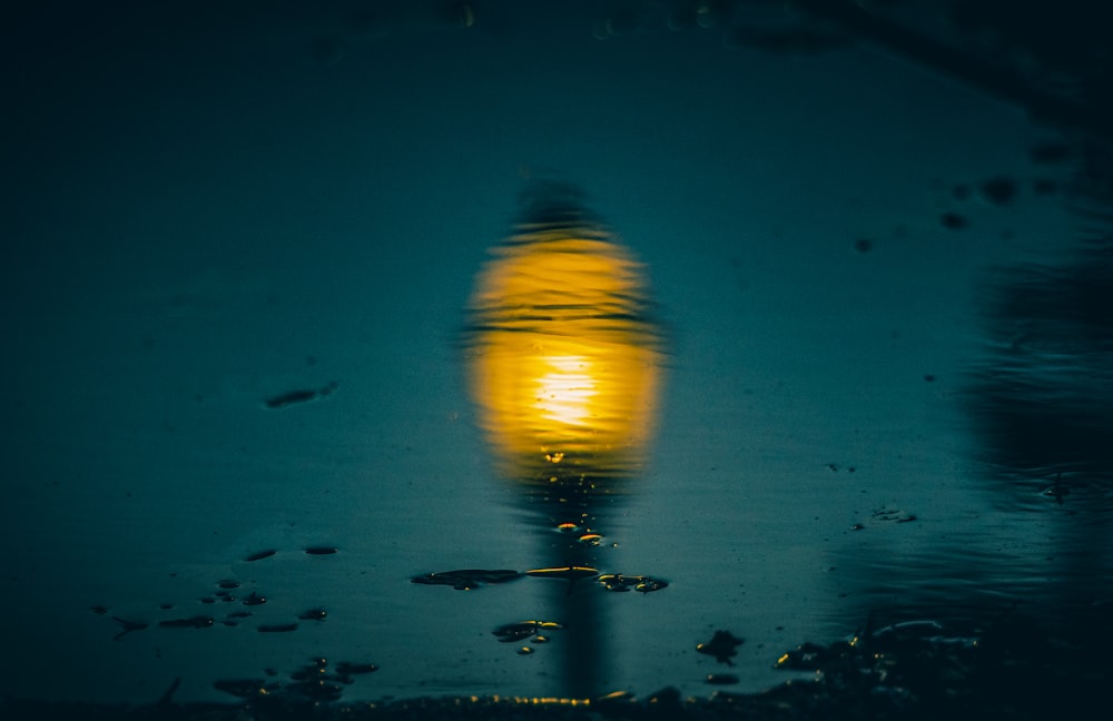 a reflection of a street light in a puddle of water