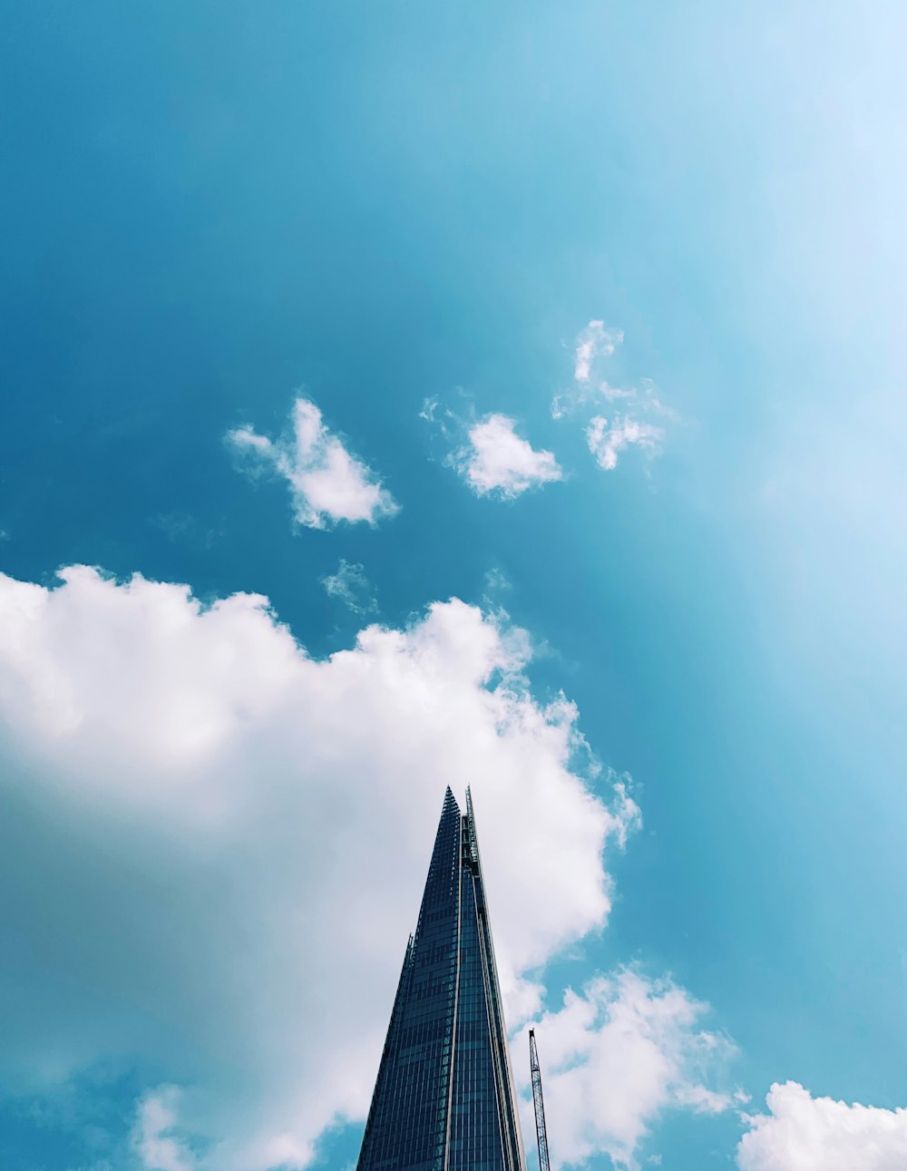 low-angle photography of high-rise building under blue and white skies during daytime