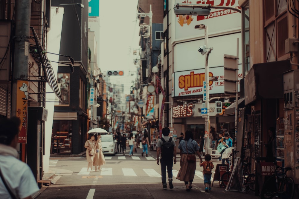 people walking near road beside buildings during daytime