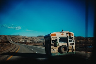 white and brown bus on road under blue and white skies during daytime