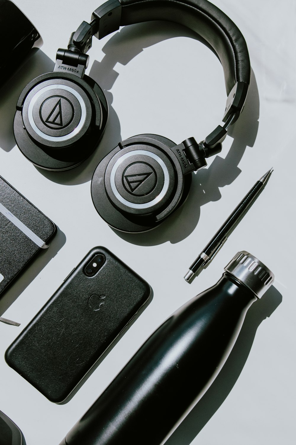 a white table topped with headphones and a cell phone